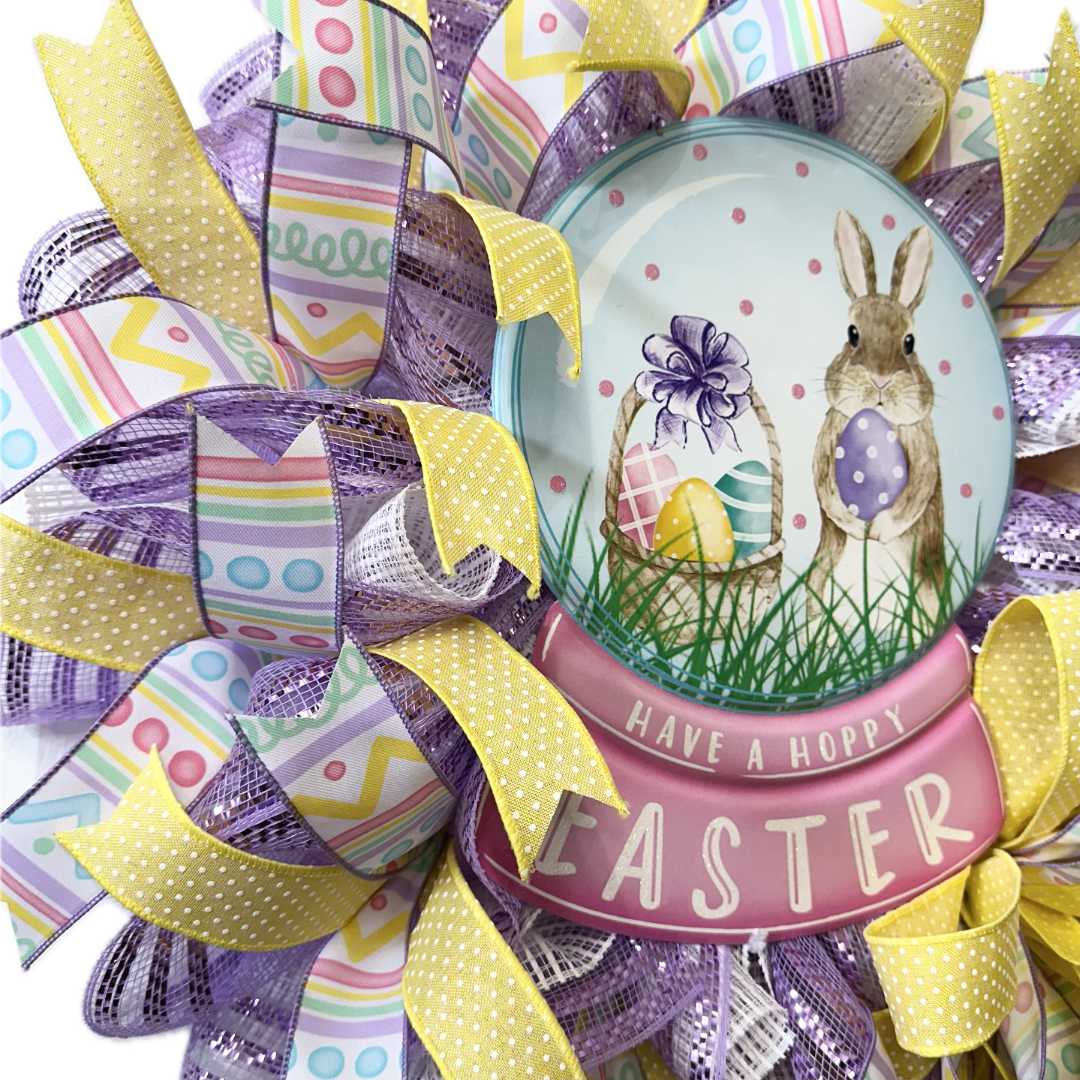 Easter-themed decorative wreath with a glass ball featuring a bunny and eggs, surrounded by colorful ribbons.