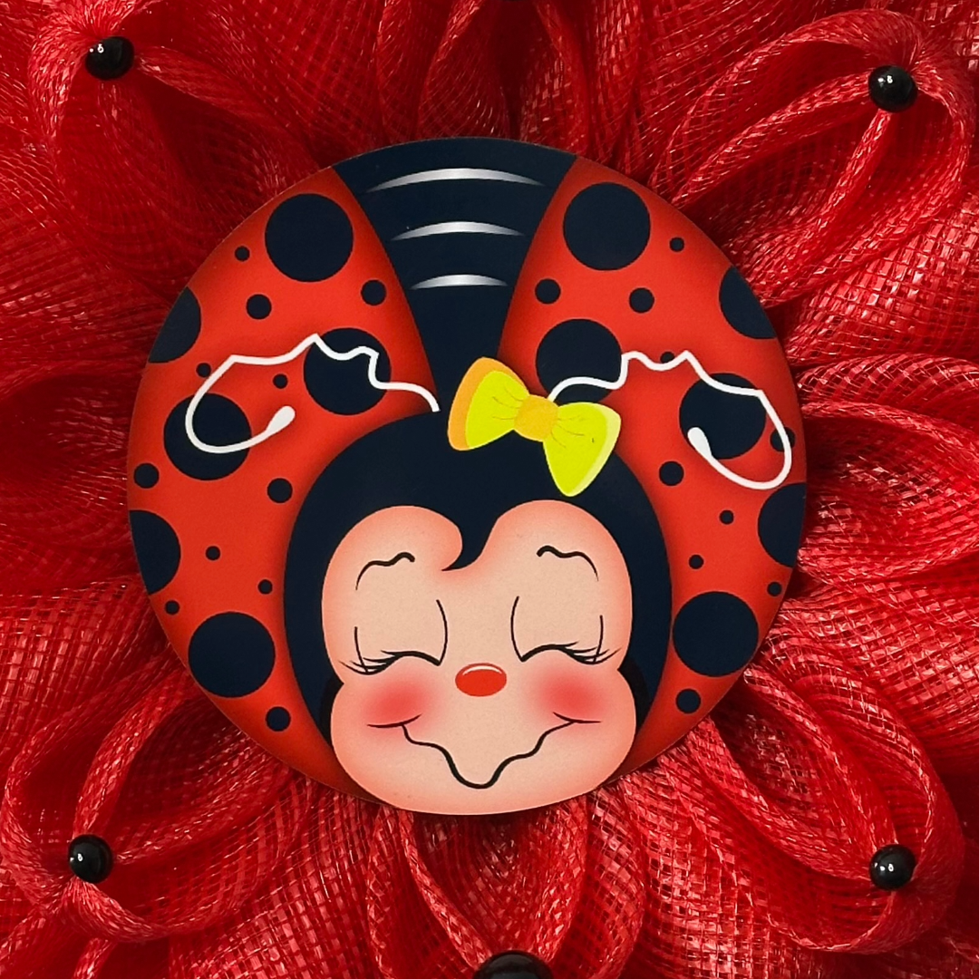 Ladybug inspired wreath with red deco mesh, black dots and a ladybug metal wreath sign in the center 