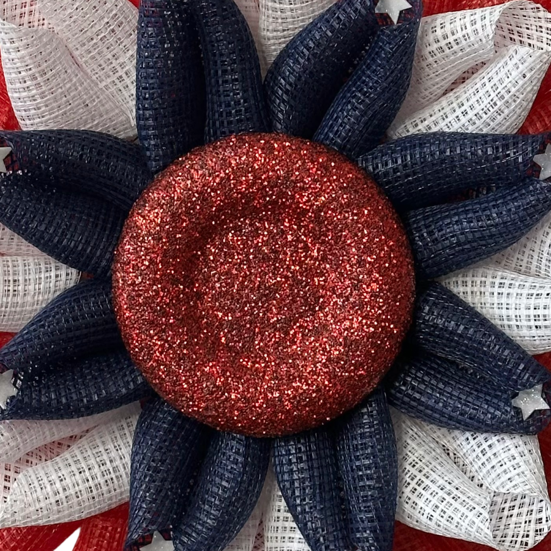 Deco mesh flower wreath with red, white, and blue colors, white stars and a red glitter center by Monkey's Creations