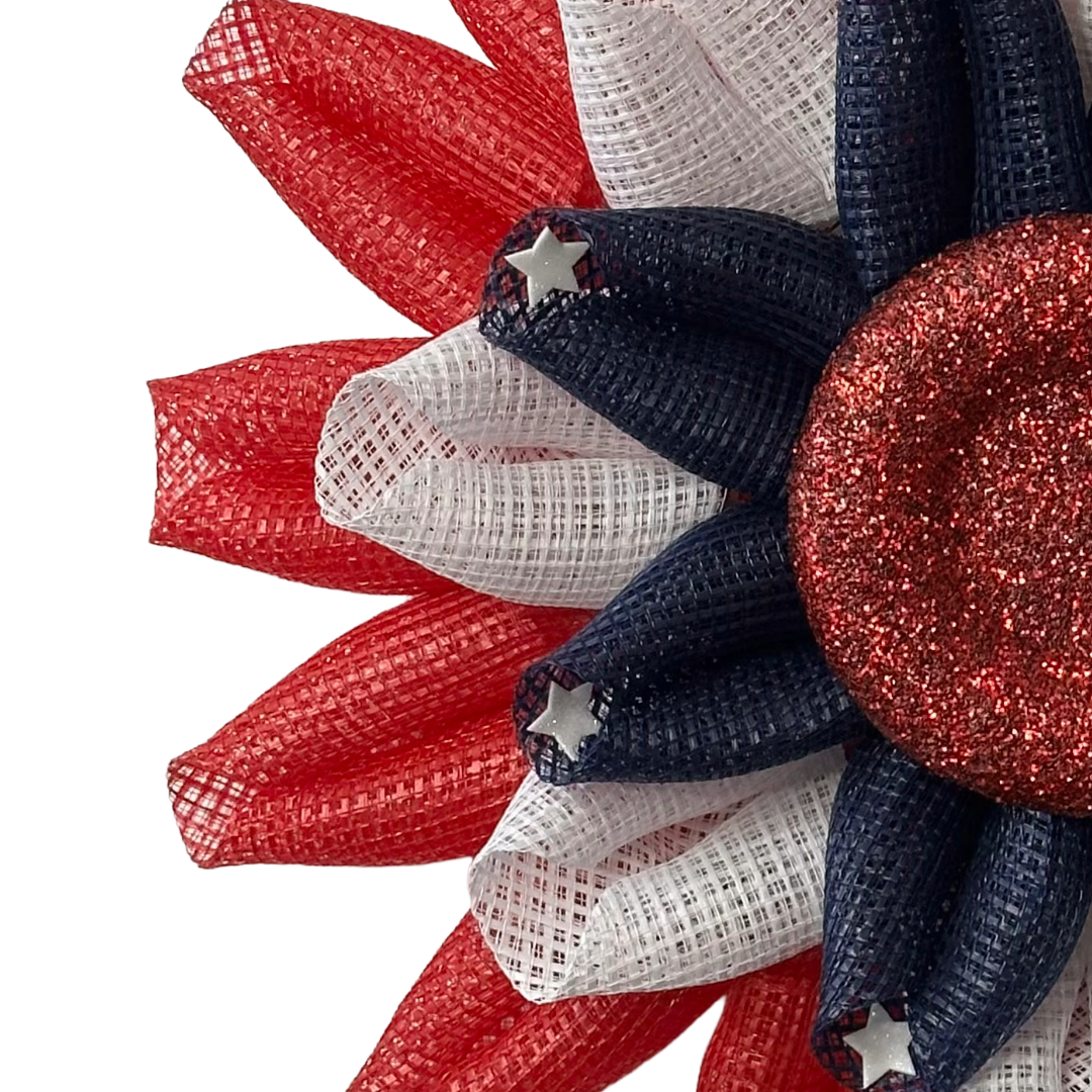 Deco mesh flower wreath with red, white, and blue colors, white stars and a red glitter center by Monkey's Creations