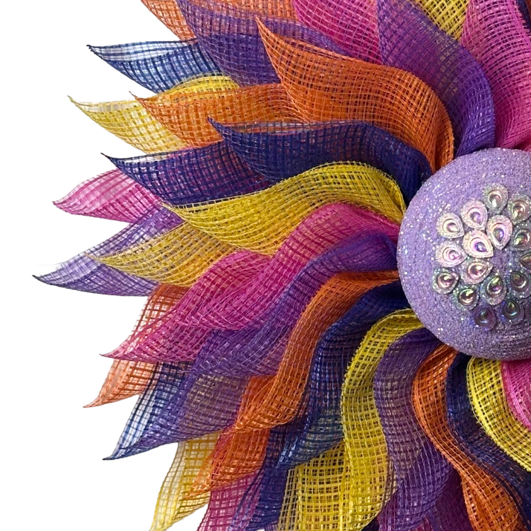 Deco mesh flower wreath with multicolored petals and an purple gemstone flower center 