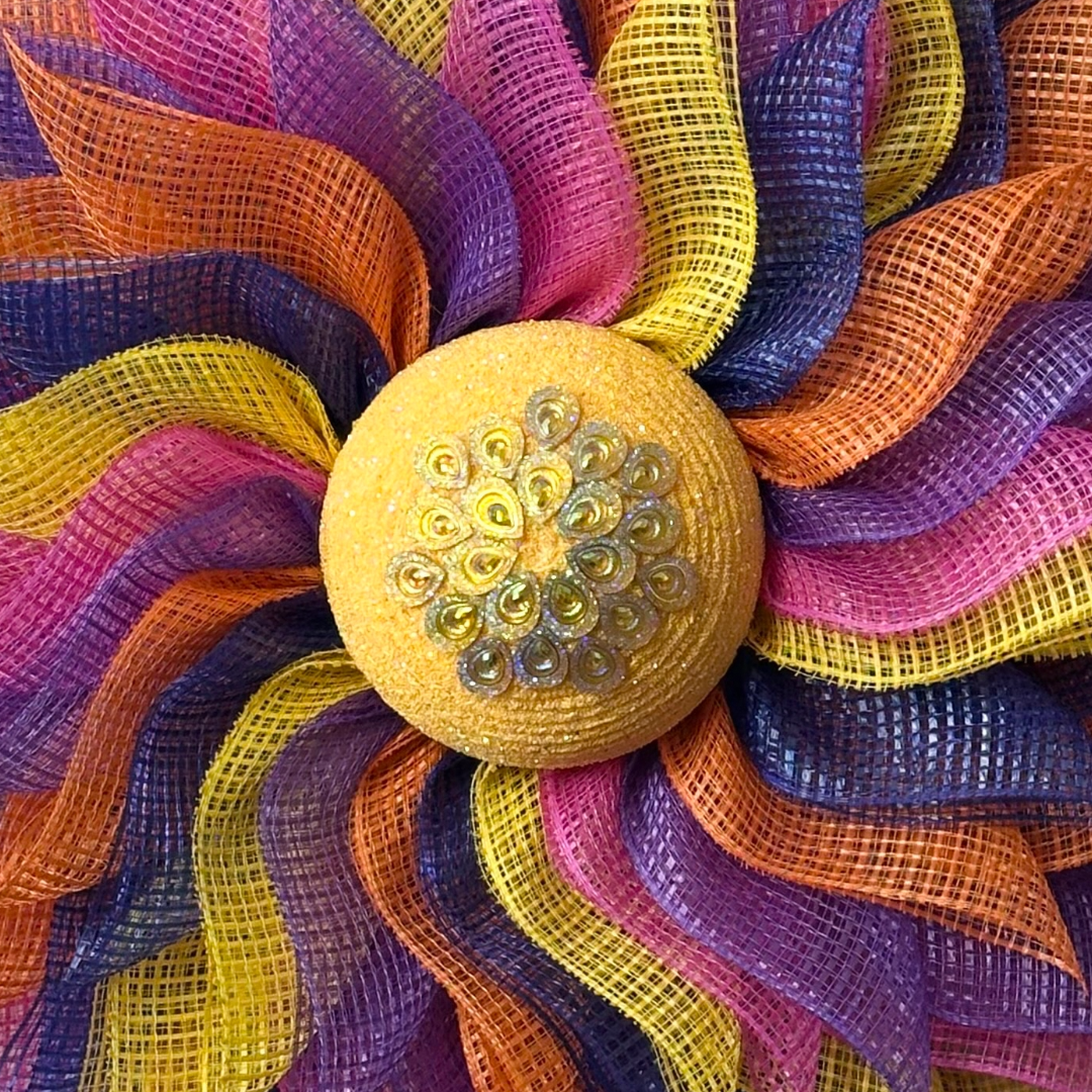 Deco mesh flower wreath with multicolored petals and an yellow gemstone flower center 