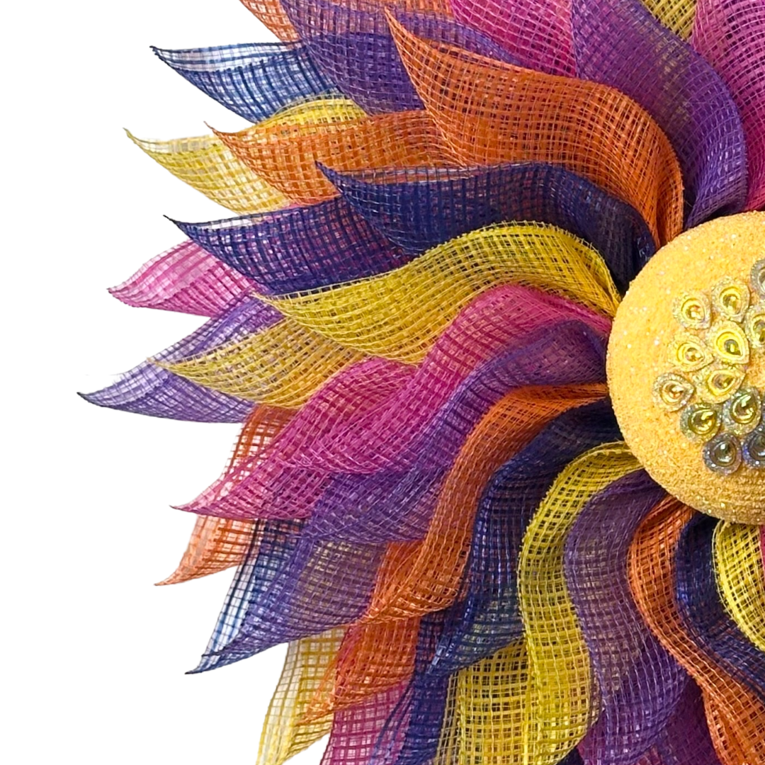 Deco mesh flower wreath with multicolored petals and an yellow gemstone flower center 