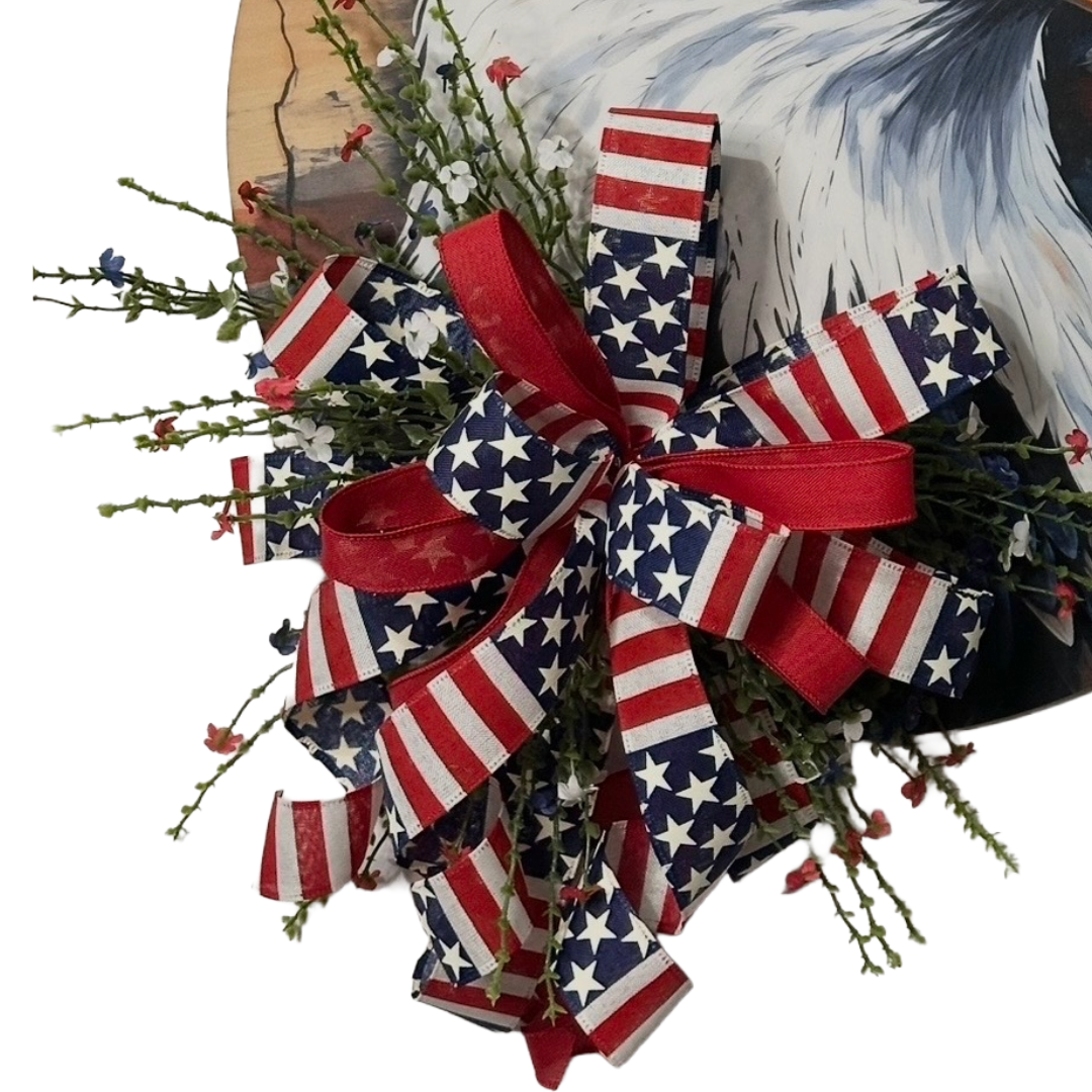 Patriotic eagle head door hanger with floral picks and a red white and blue themed ribbon bow by Monkey's Creations