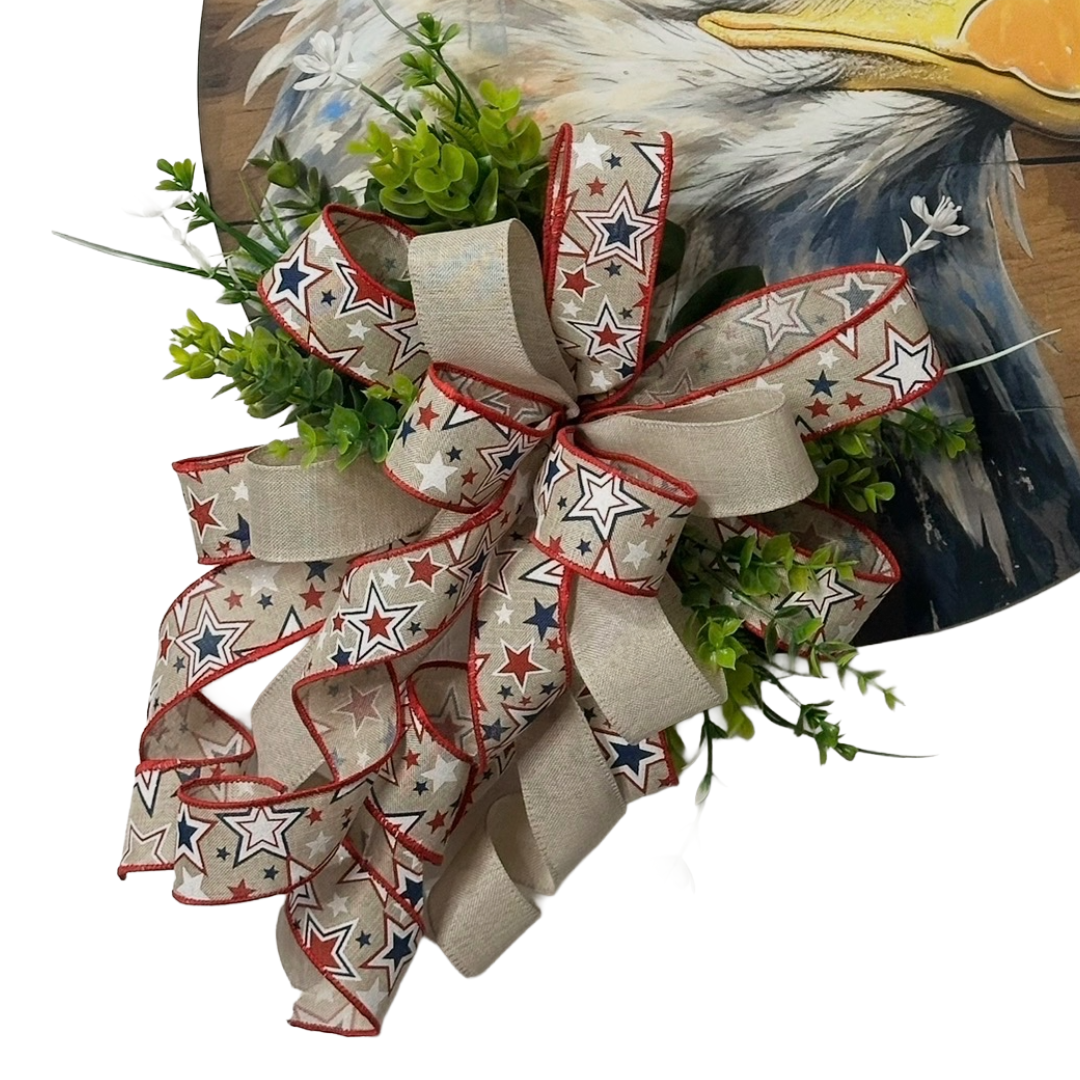 Patriotic eagle head door hanger with floral picks and a red white and blue themed ribbon bow by Monkey's Creations
