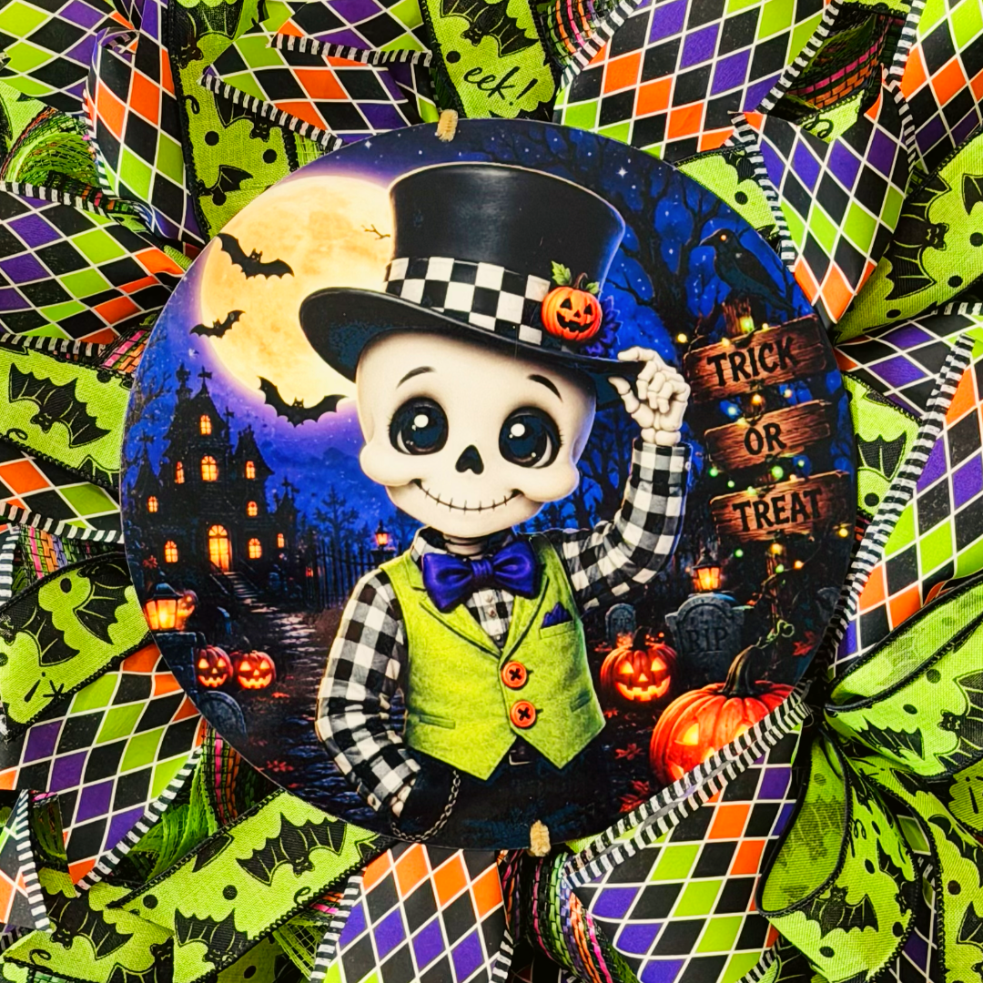 Orange, purple, black and lime green Halloween deco mesh and ribbon wreath featuring a round dapper skeleton with "trick or treat" metal wreath sign and a large ribbon bow by Monkey's Creations. 