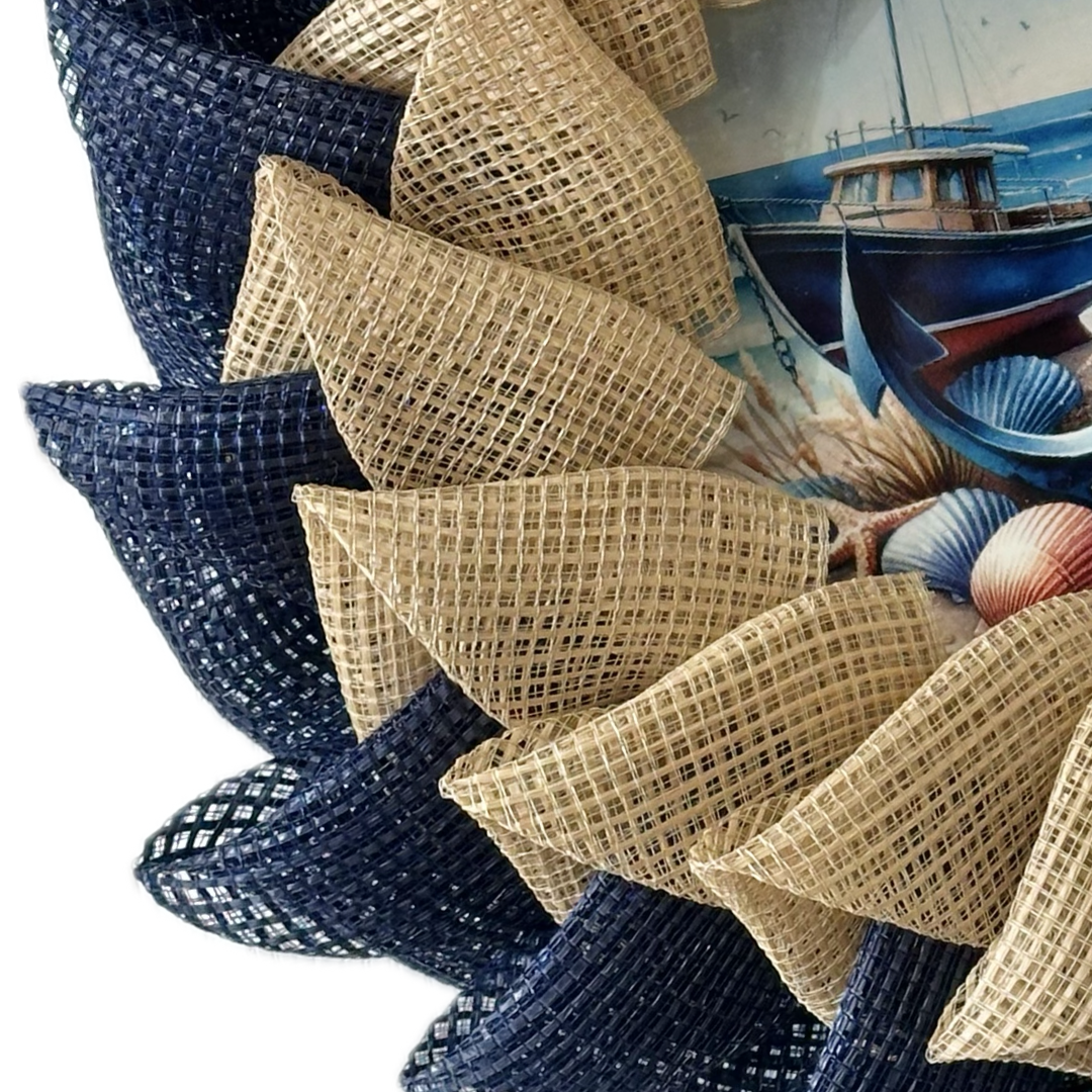 Nautical-themed decorative wreath with blue and beige deco mesh, including a boat painting in the background.