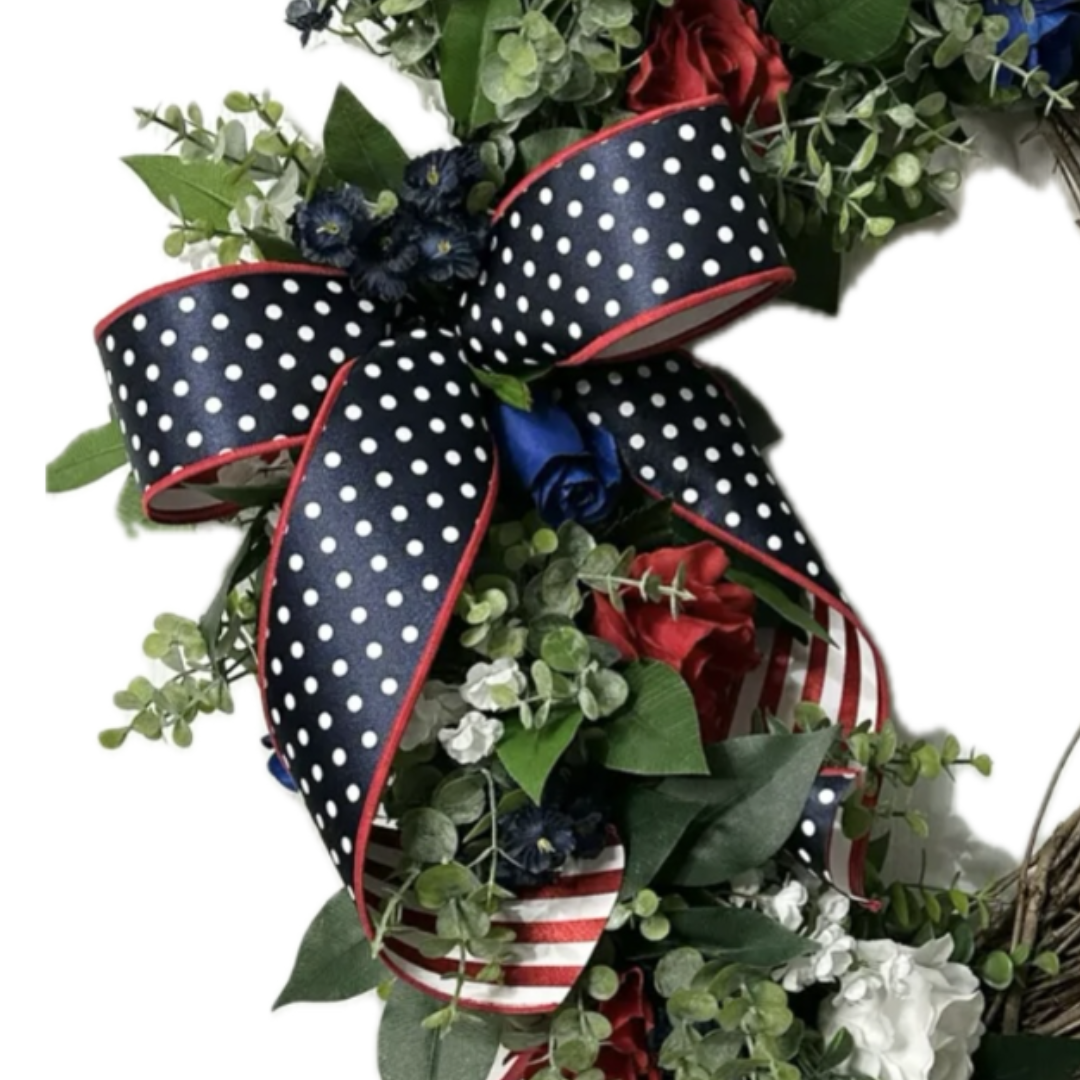 Patriotic grapevine wreath with greenery, flowers, roses and red white and blue ribbon, focus on ribbon