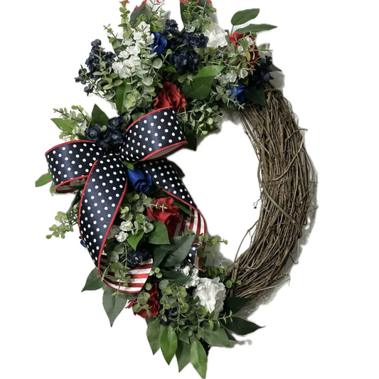 Patriotic grapevine wreath with greenery, flowers, roses and red white and blue ribbon