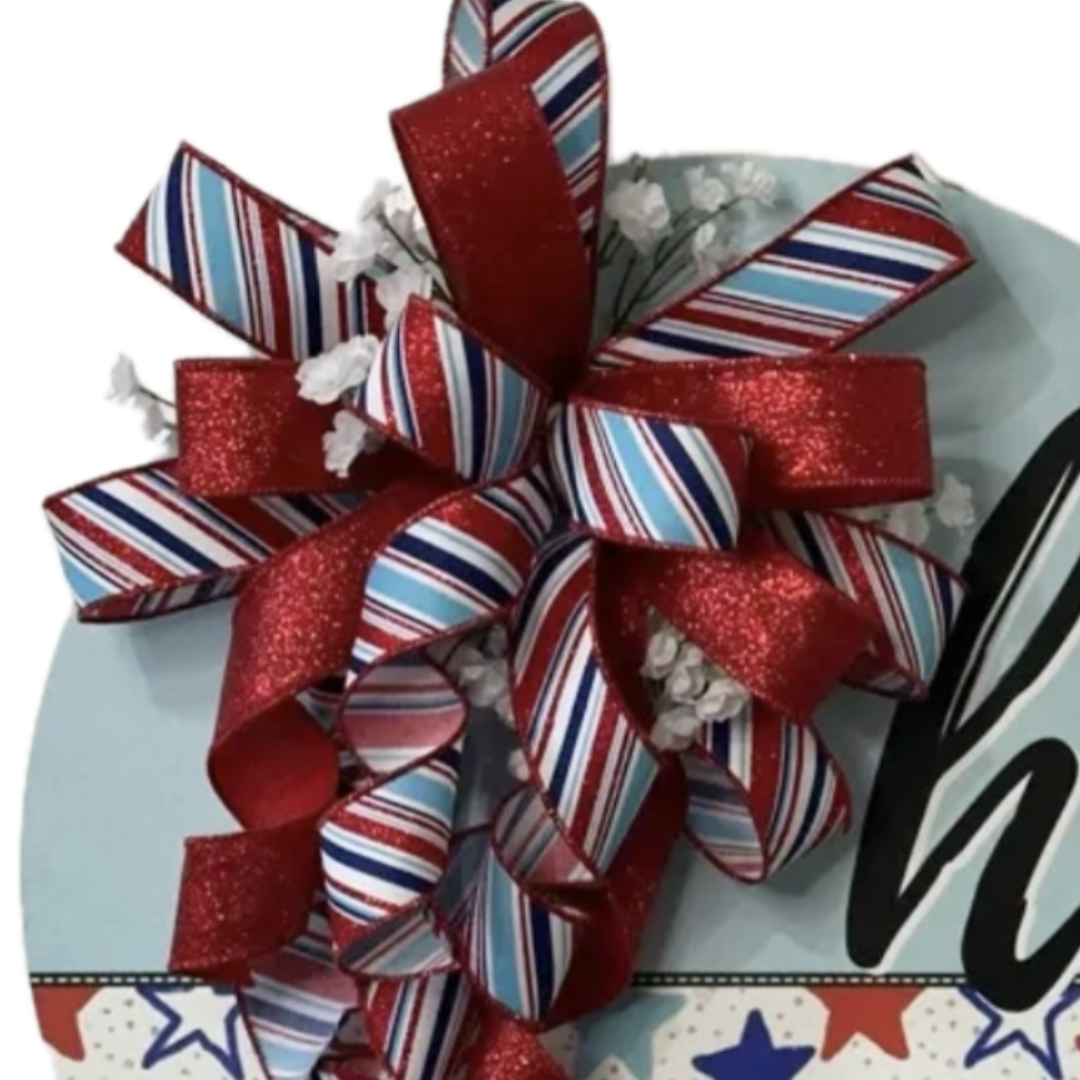 Patriotic round hi wreath with red white and blue stars, flowers and ribbon, focus on the ribbon