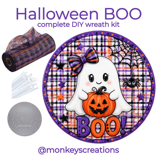Complete DIY wreath kit featuring a roll of purple and orange plaid deco mesh, zip ties, a small board and a round metal Halloween ghost wreath sign with "BOO" by Monkey's Creations. 