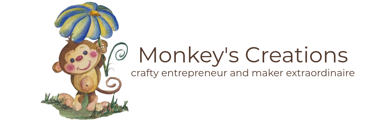 Logo of 'Monkey's Creations' featuring a cartoon monkey with a colorful umbrella on a white background.