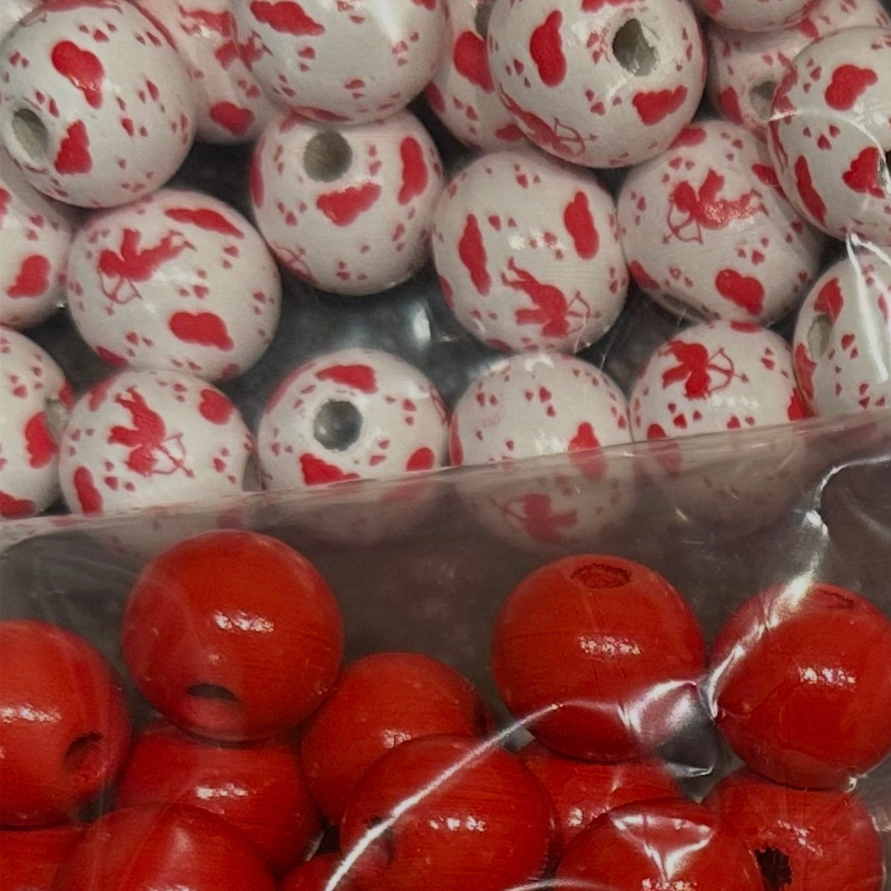 close up of red wooden beads and white wooden beads with cupid and hearts