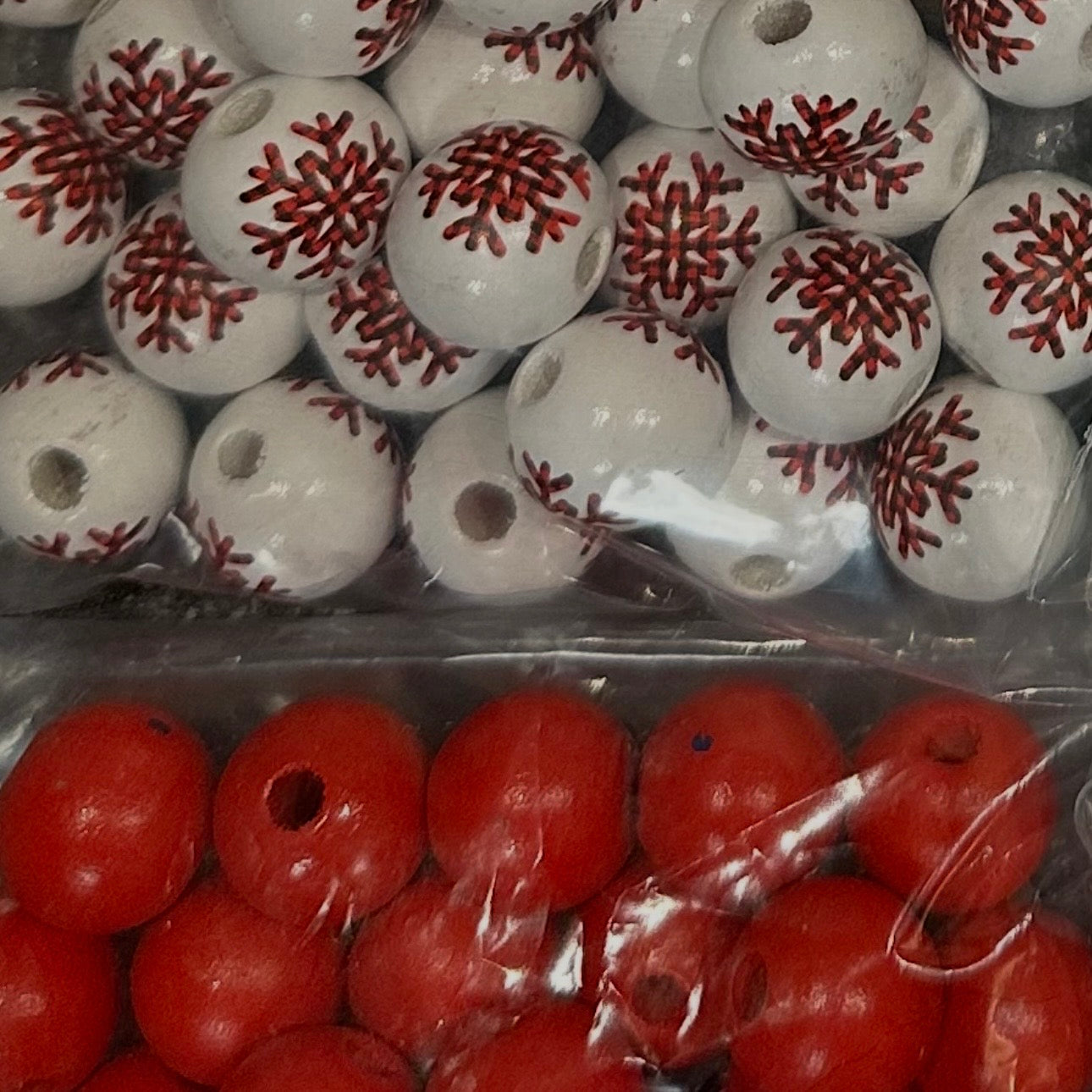 close up of red wooden beads and white beads with red and black snowflakes